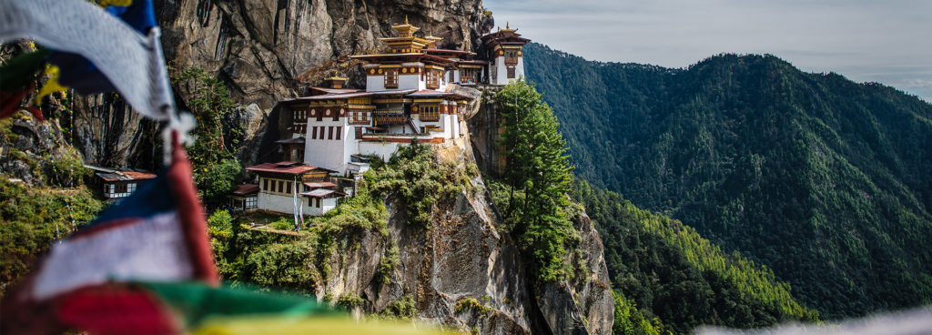 Bhutan's incredible Tiger's Nest Monastery with prayer flags in the foreground.
