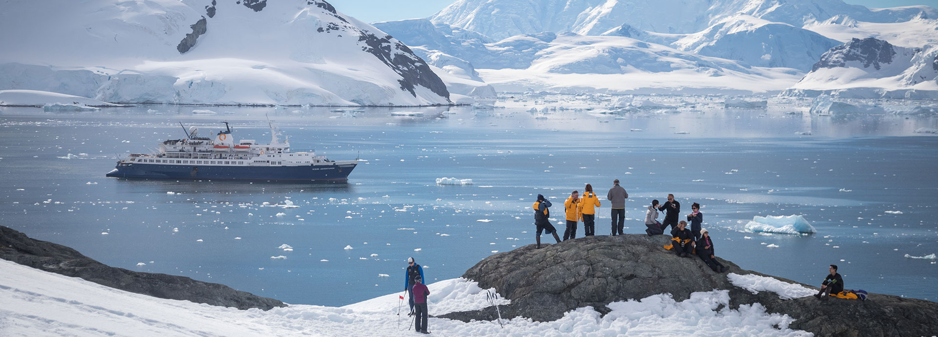 Tourists take in the spectacular Antarctic scenery from a rocky headland