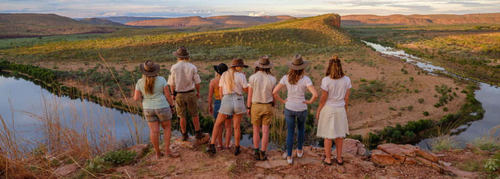 Group of hikers stand on an escarpment overlooking Chamberlain Gorge