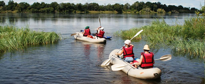 Tourists canoe on the Okavango Delta on affordable safaris in Botswana