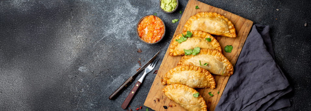Latin American fried empanadas with tomato and avocado sauces. Gastronomy Chile tours.