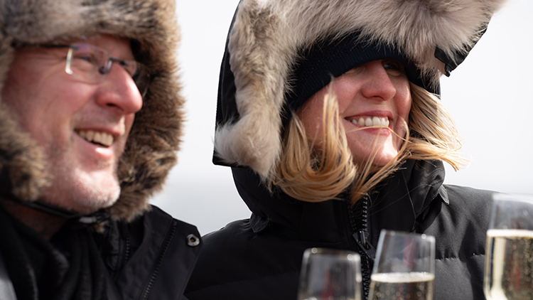 Couple in polar clothing enjoying champagne