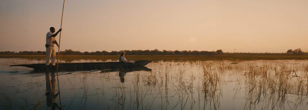 Woman taking a mokoro ride through the Okavango Delta with an expert guide.