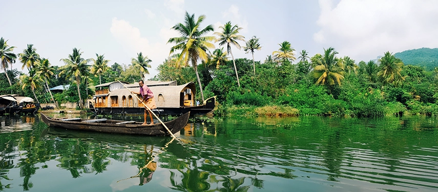 A palm-lined canal scene with houseboats in Kerala, India