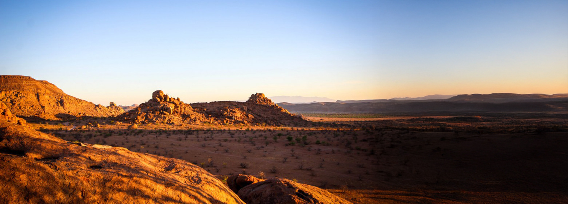 Barren landscape of Namibia with the sun setting in the background
