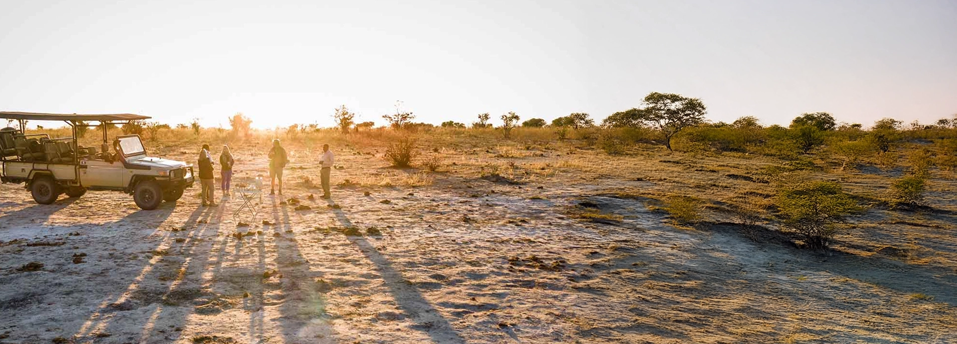 Sunrise safari stop near Mankwe Tented Retreat with open game vehicle and guests