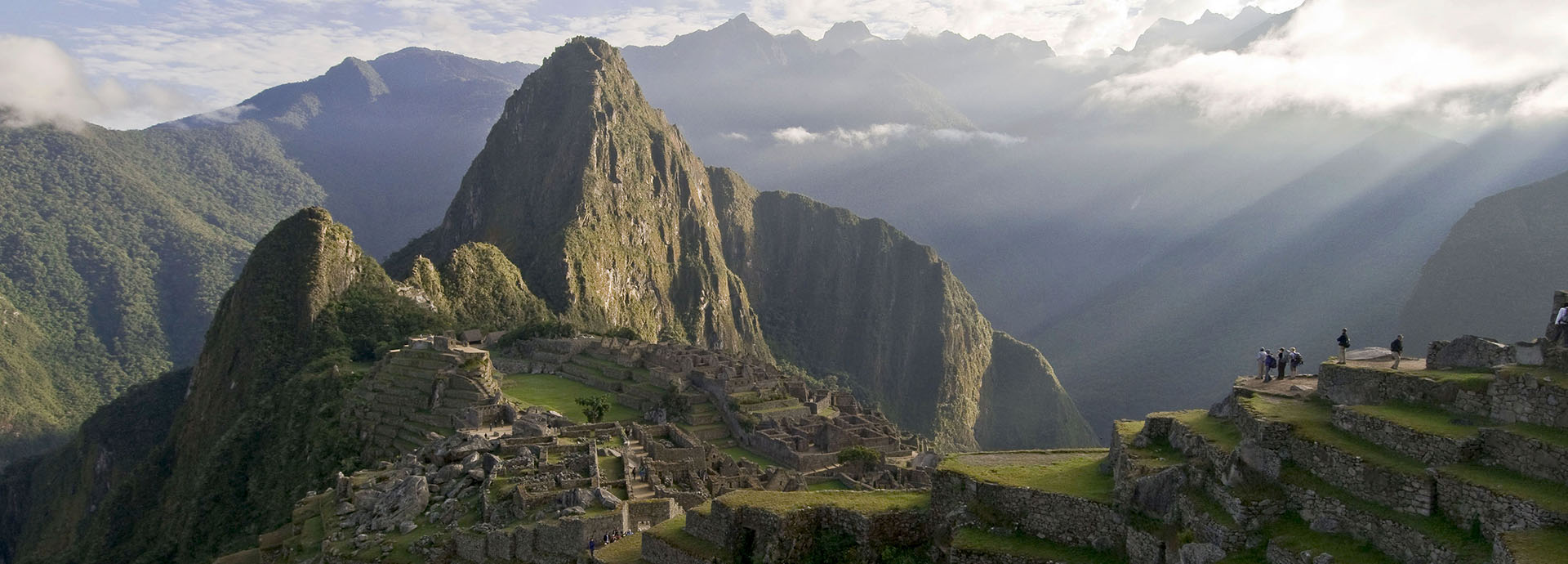 Visitors overlooking the ruins of Machu Picchu and the Andes mountains