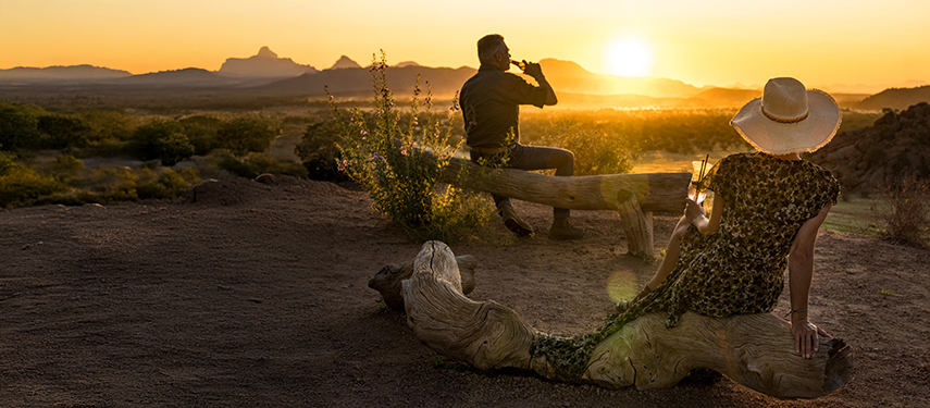 Couple enjoy sundowners while on safari in Namibia