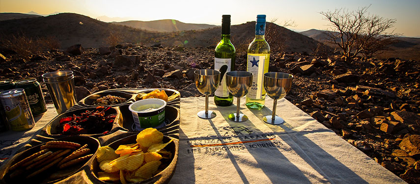 Sundowners with endless views of Damaraland at Huab Under Canvas in Namibia