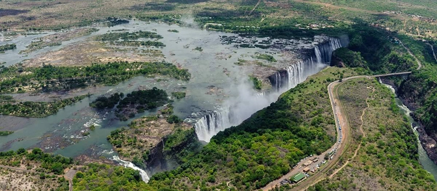 Aerial perspective of Victoria Falls with lush green surroundings and winding river channels on the Grand Zambezi Safari.