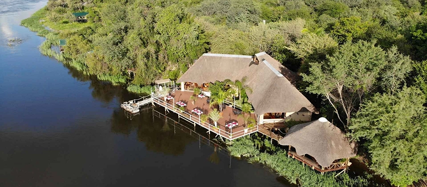 Riverside thatched lodge with dining deck at Nunda River Lodge