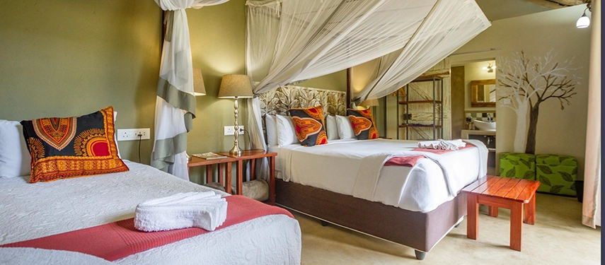 Triple room with mosquito nets & African textiles at Robins Camp