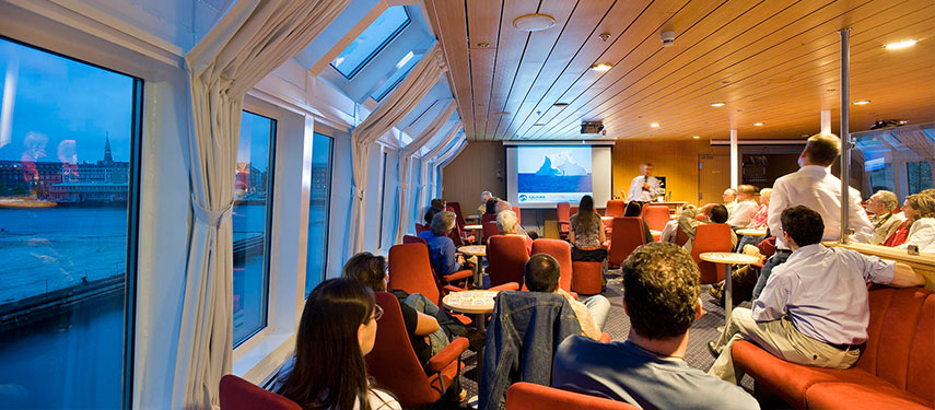 Guests enjoy a lecture aboard an Antarctic cruise ship