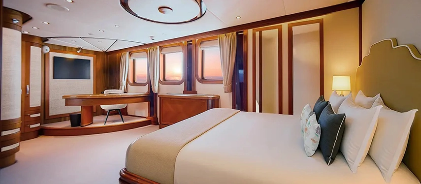 Spacious suite with king bed, large windows and refined wooden detailing.