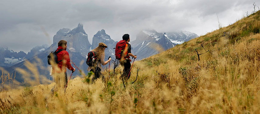 Hikers walk the the dramatic landscapes of Torres del Paine Patagonia