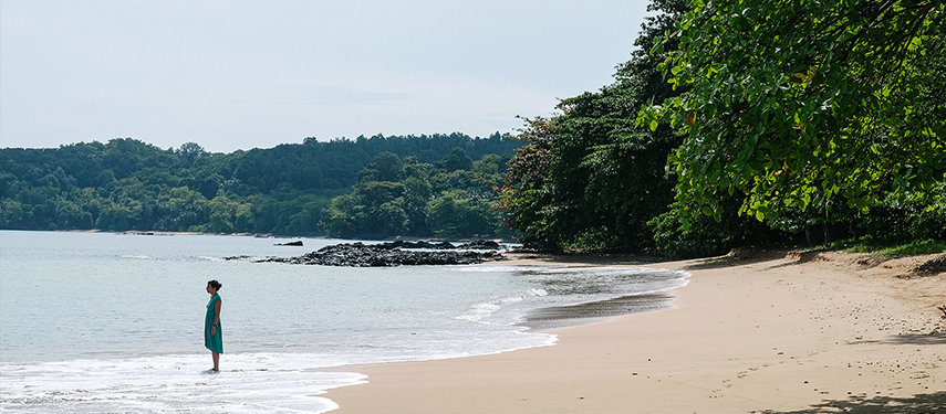 A lady standing on the beach of São Tomé and Príncipe