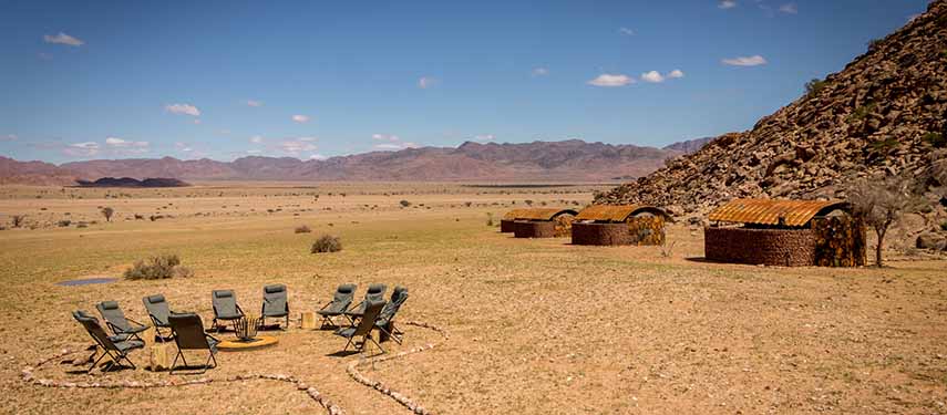 Sit around the campfire with expansive views of the desert and mountains at Sossus Under Canvas